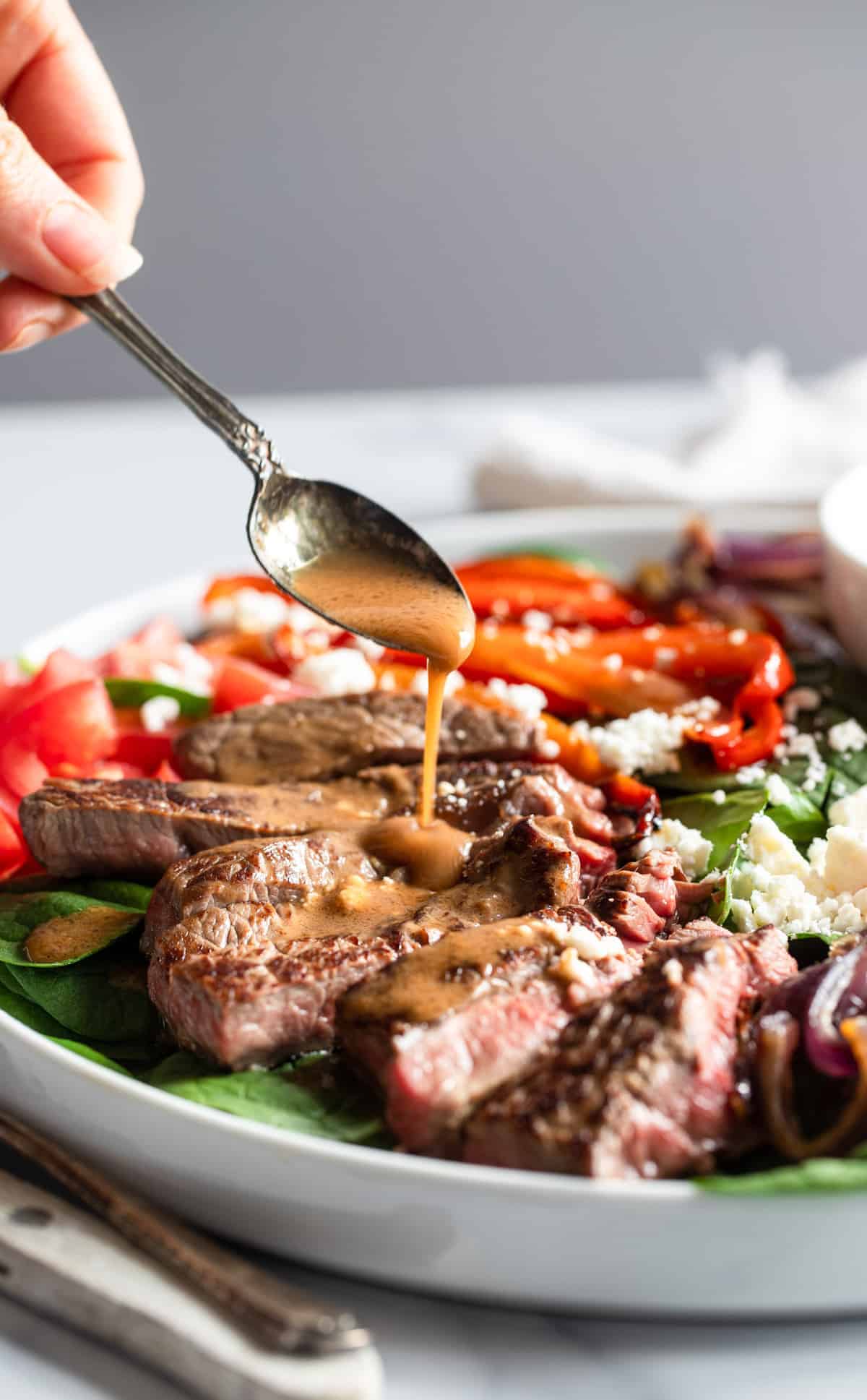 Balsamic Steak Salad being served with sauce