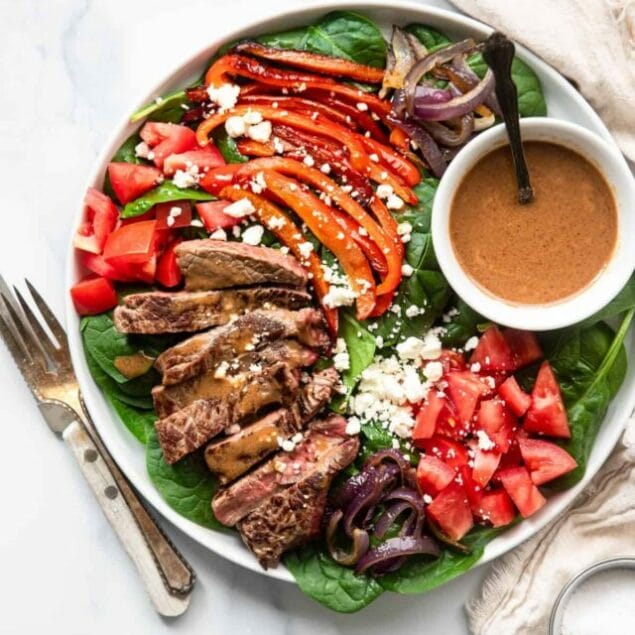 tasty balsamic steak salad served on a plate with fork and knife