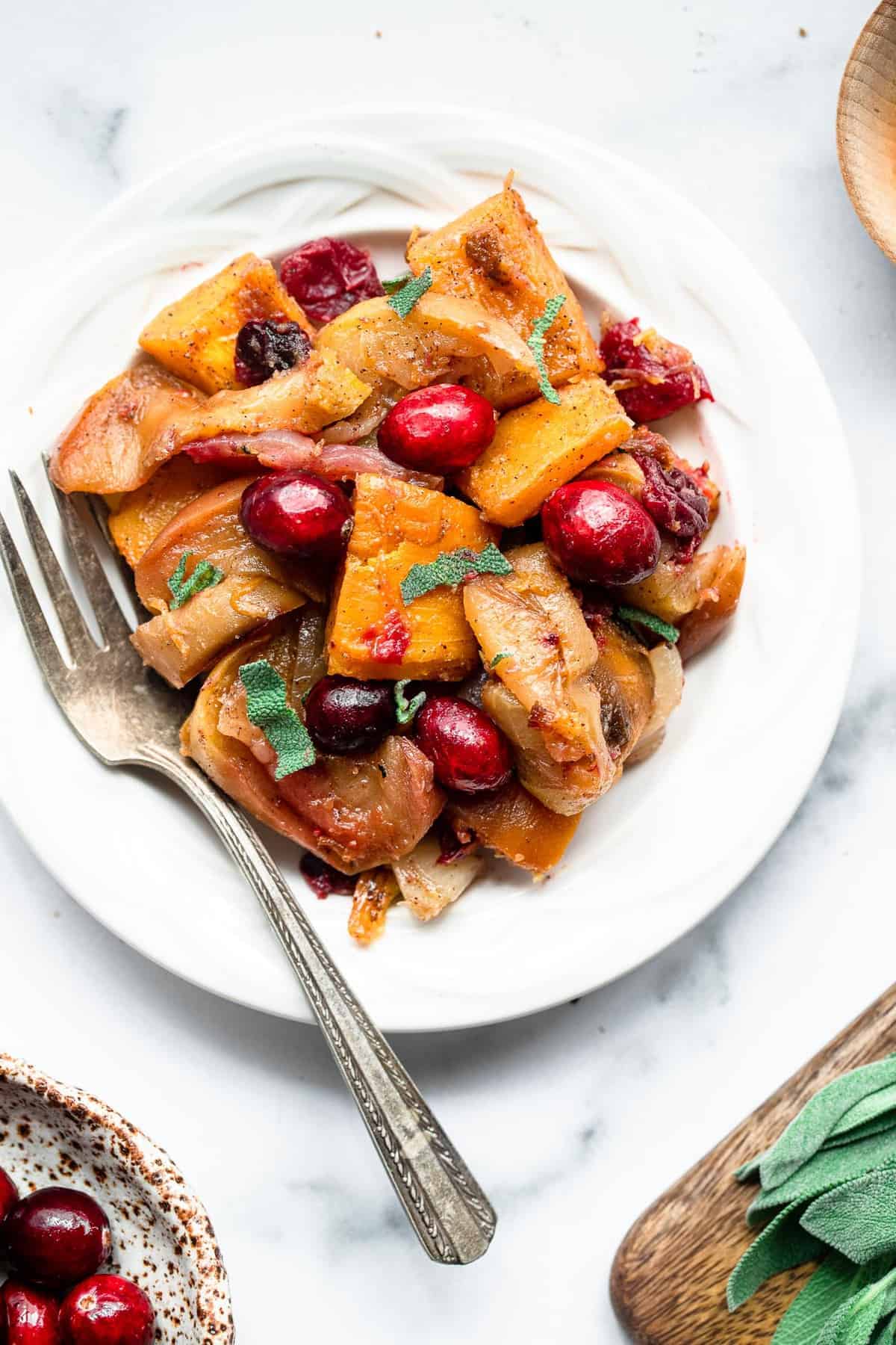 baked pumpkin on a plate with cranberries and apples