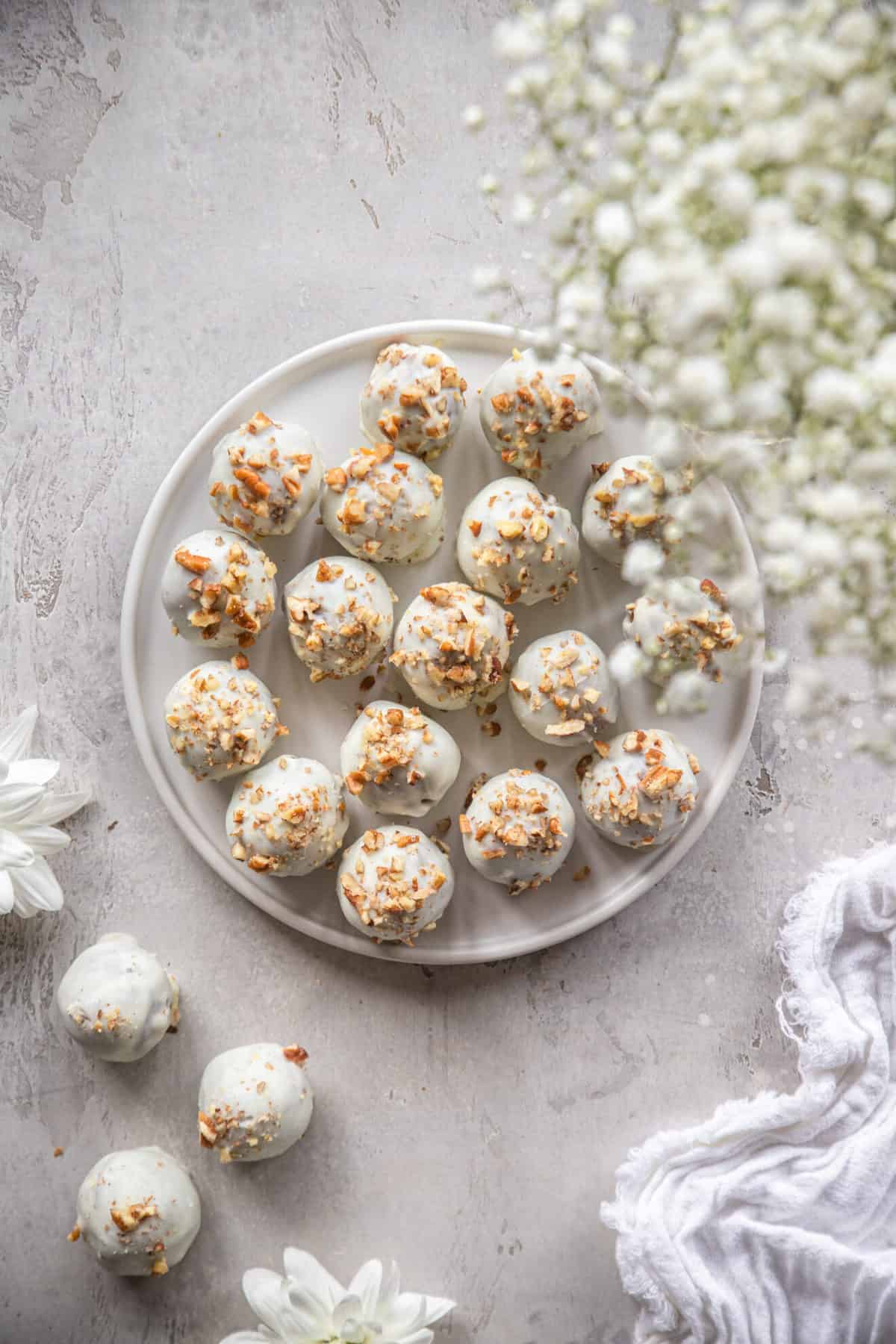 Carrot Cake balls on a plate with some flowers