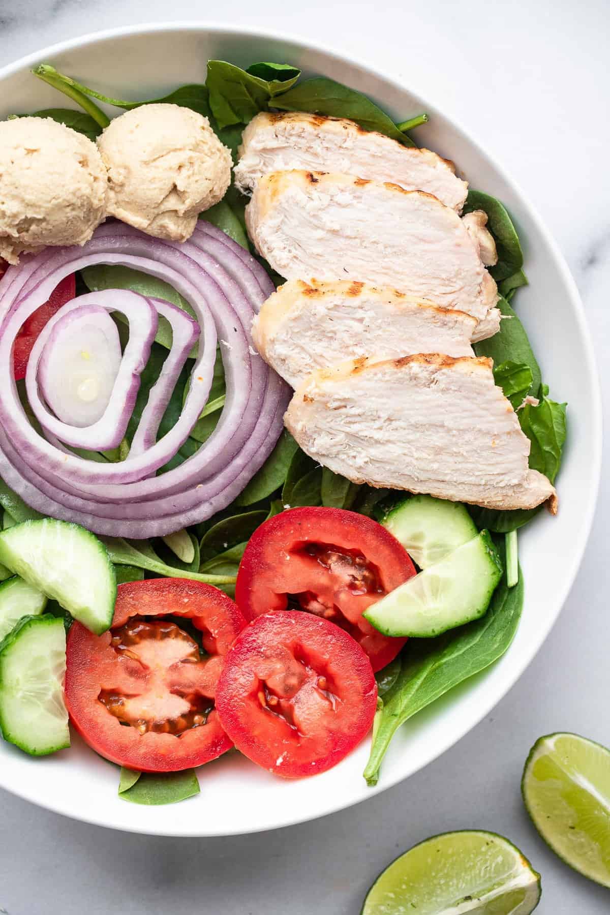  salade de protéines dans un bol avec du poulet, du concombre et de la tomate 