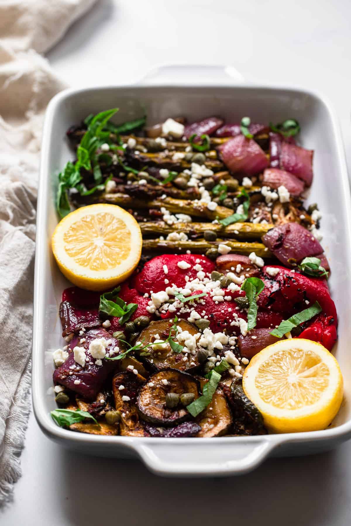 Balsamic grilled vegetable salad in a baking dish with lemon on top