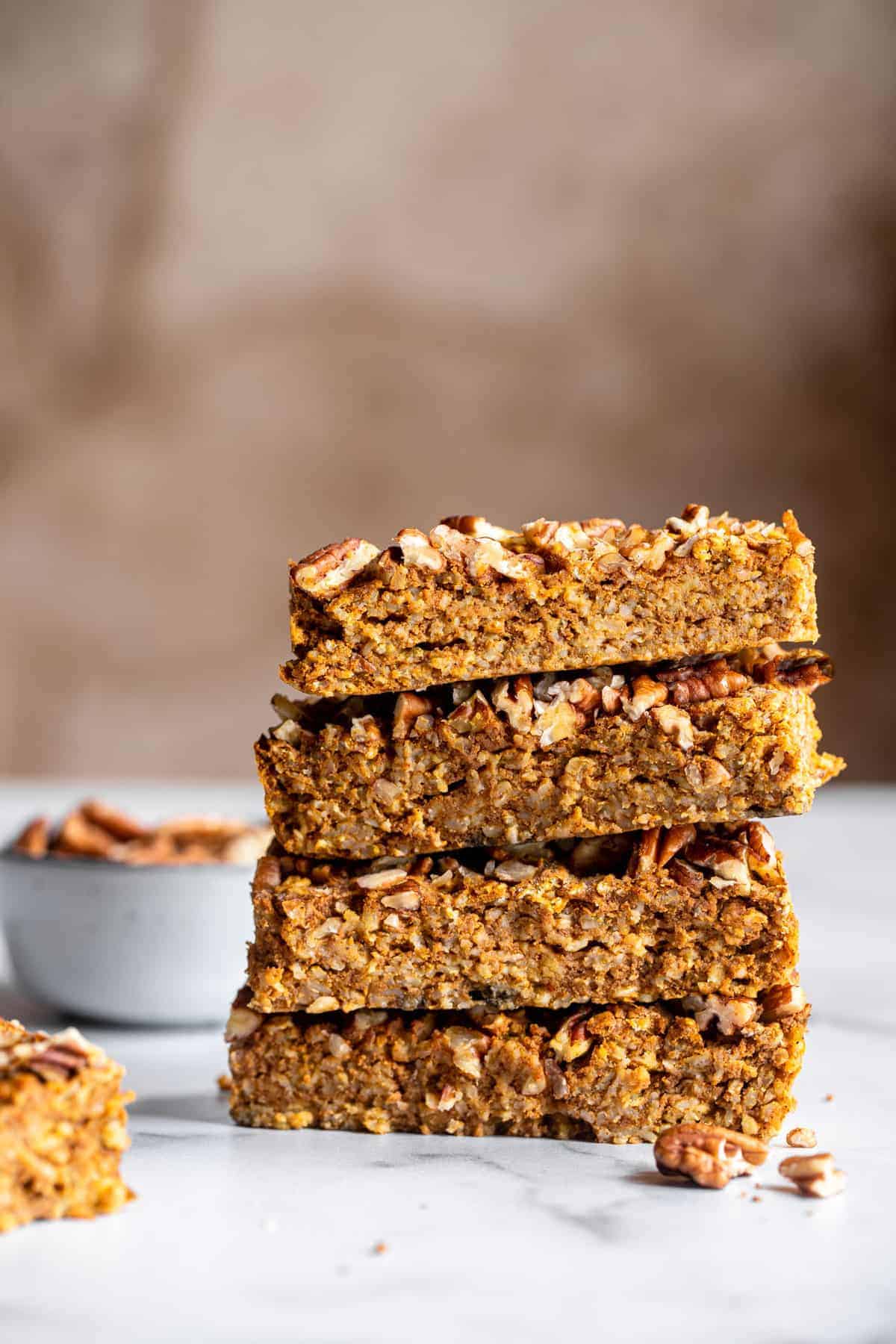 homemade pumpkin protein bars stacked on top of each other on the counter