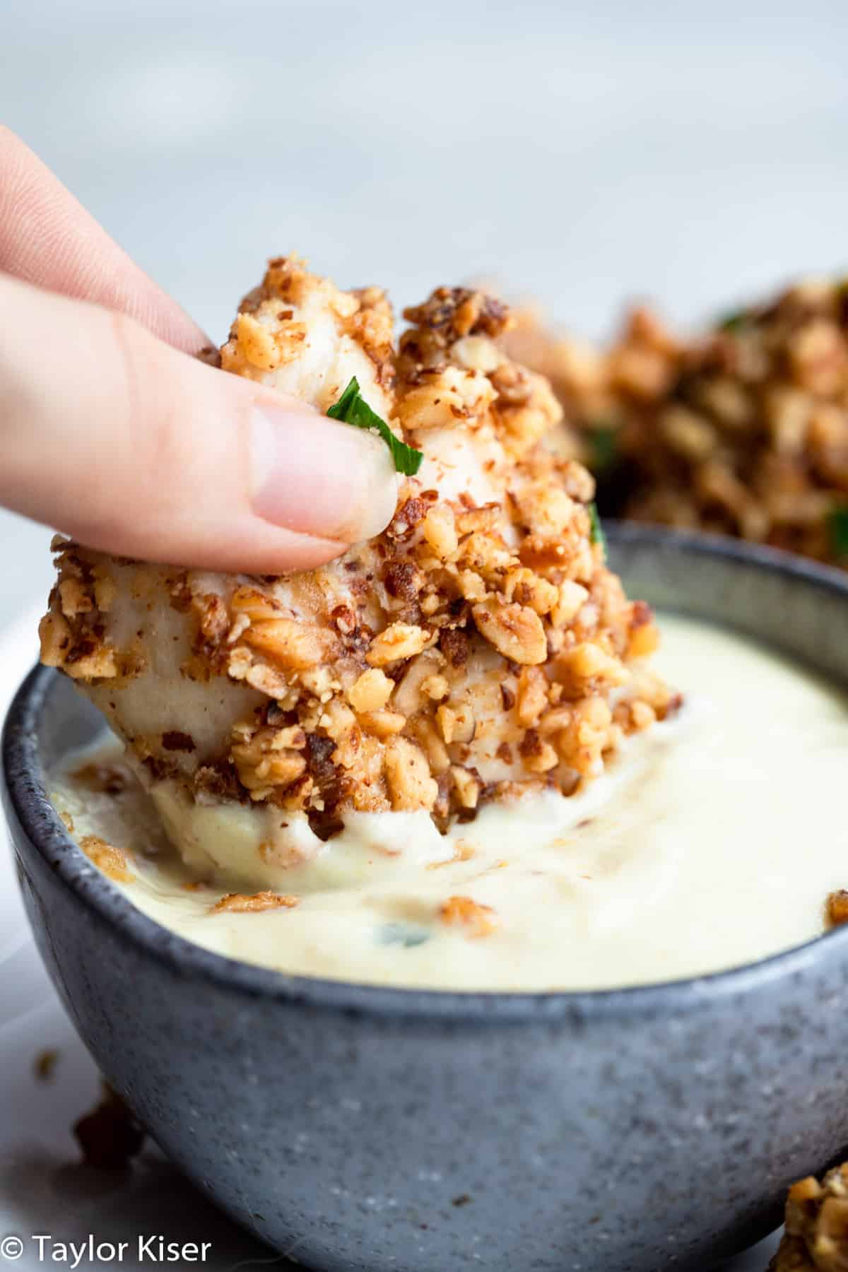 baked almond crusted chicken bites dipping in a sauce