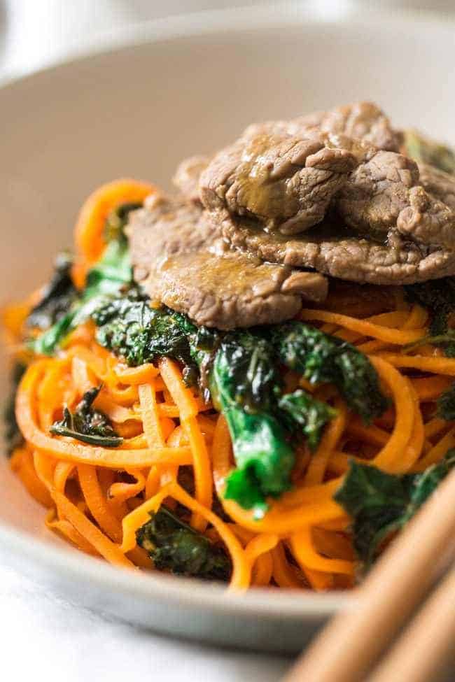 Spiralized Paleo Orange Beef Stir Fry with Kale and Sweet Potato Noodles - A healthy twist on takeout that is ready in 20 minutes! | Foodfaithfitness.com | @FoodFaithFit