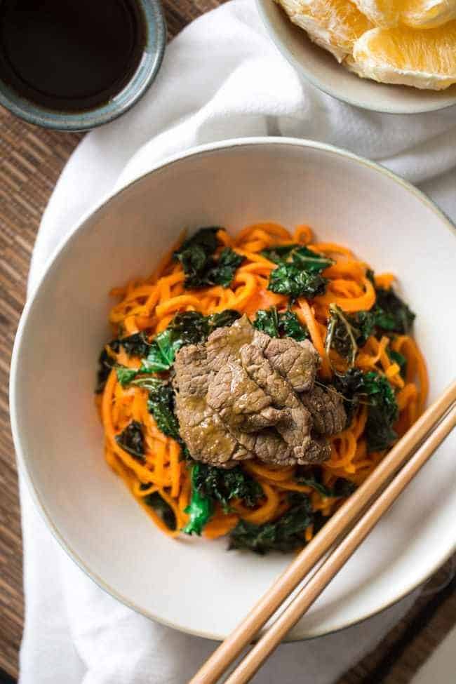 Spiralized Paleo Orange Beef Stir Fry with Kale and Sweet Potato Noodles - A healthy twist on takeout that is ready in 20 minutes! | Foodfaithfitness.com | @FoodFaithFit