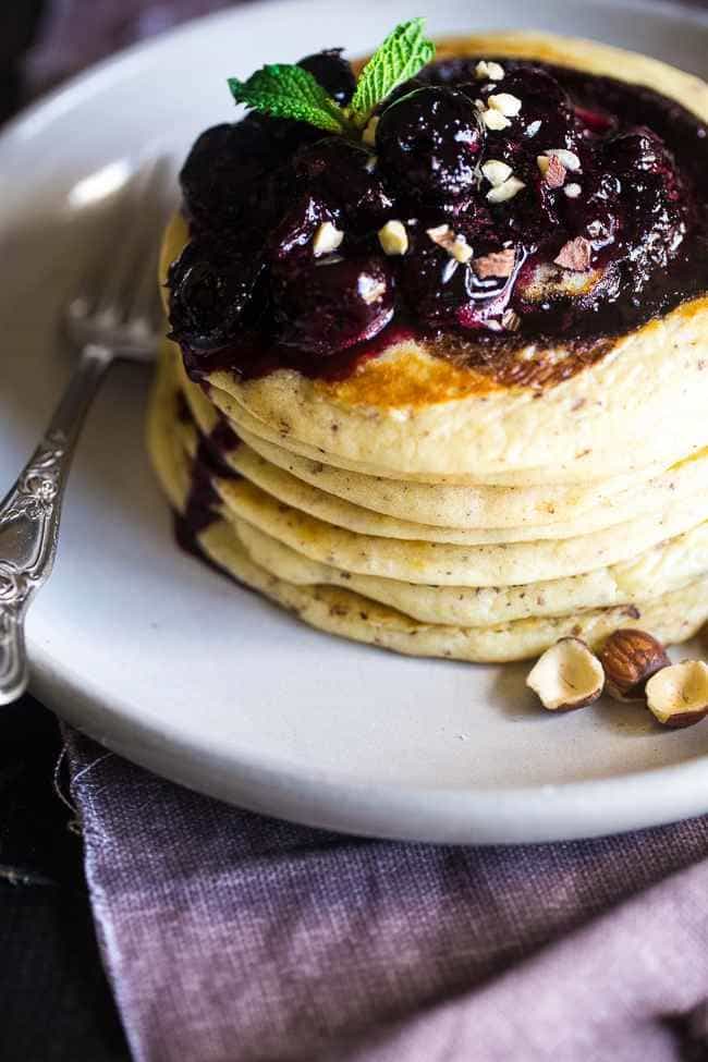 Chocolate Swirled Gluten Free Pancakes with Cherry Sauce and Hazelnuts – Ooey, gooey and so decadent! These pancakes are SO easy and perfect for Mother’s Day or brunch! | Foodfaithfitness.com | @FoodFaithFit
