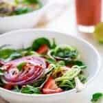Vegan Spiralized Cucumber Salad with Chia Strawberry Vinaigrette - This healthy cucumber salad recipe is mixed with fresh herbs, strawberries and a homemade lime-strawberry vinaigrette. It's a fresh, paleo & vegan meal for only 230 calories! | Foodfaithfitness.com | @FoodFaithFit
