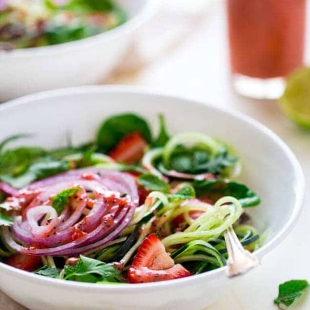 Vegan Spiralized Cucumber Salad with Chia Strawberry Vinaigrette - This healthy cucumber salad recipe is mixed with fresh herbs, strawberries and a homemade lime-strawberry vinaigrette. It's a fresh, paleo & vegan meal for only 230 calories! | Foodfaithfitness.com | @FoodFaithFit