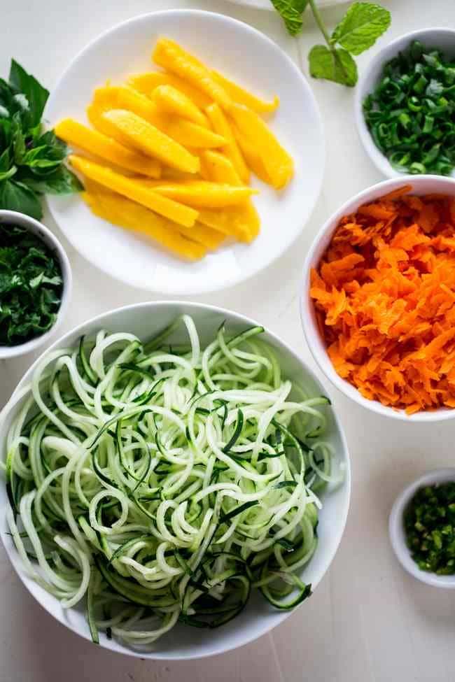 Vegan Spiralized Cucumber Noodles Mango Summer Rolls with Almond Coconut Dip - These summer rolls are made with mango and cucumber noodles, instead of rice noodles, to make them lower carb. Serve them with almond butter and coconut dip for a light and healthy, raw meal! | Foodfaithfitness.com | @FoodFaithFit
