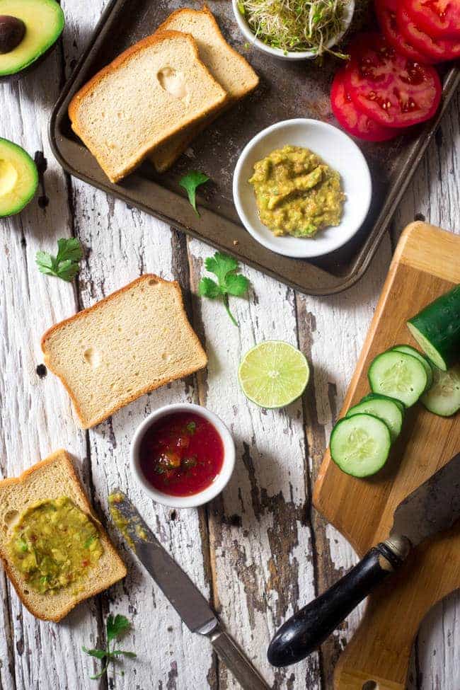 Mexican Avocado and Veggie Gluten Free Sandwiches - Slices of bread are layered with a creamy Mexican avocado spread, spicy sprouts, tomatoes and cucumbers. They're an easy, healthy meatless lunch option for under 250 calories! | Foodfaithfitness.com | @FoodFaithFit