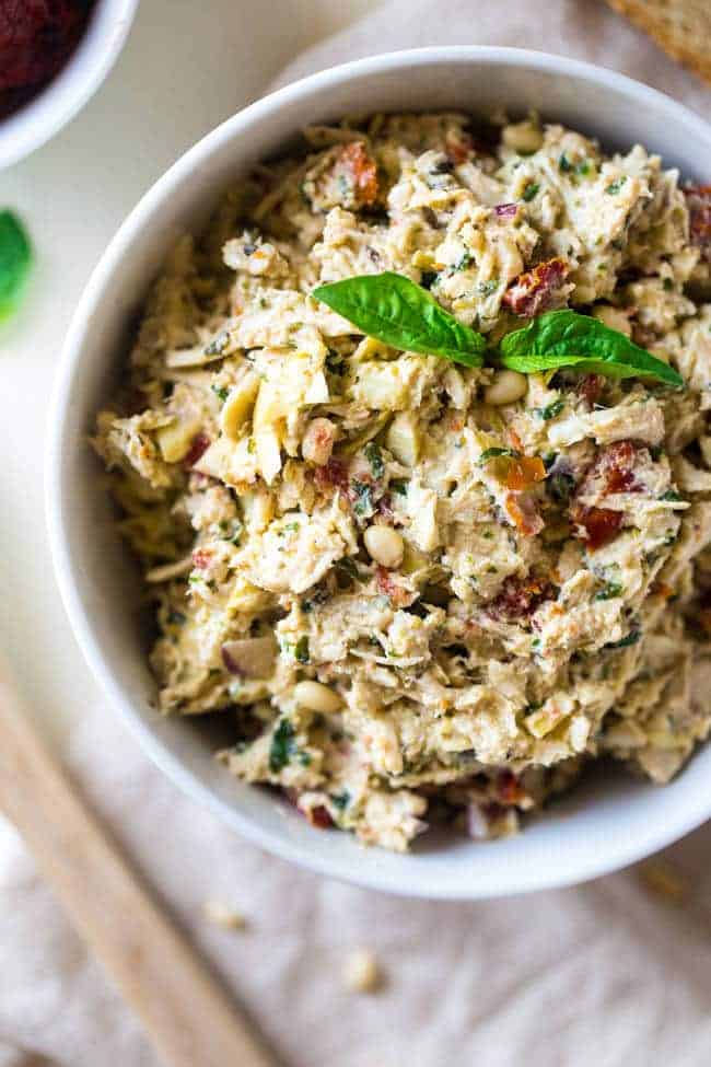 Healthy Greek Yogurt Chicken Salad without Mayo - This creamy chicken salad is made with Greek yogurt, basil, artichokes, pine nuts and sun dried tomatoes for a quick and easy meal that is secretly healthy! Perfect for a Greek yogurt chicken salad sandwich! | Foodfaithfitness.com | @FoodFaithFit