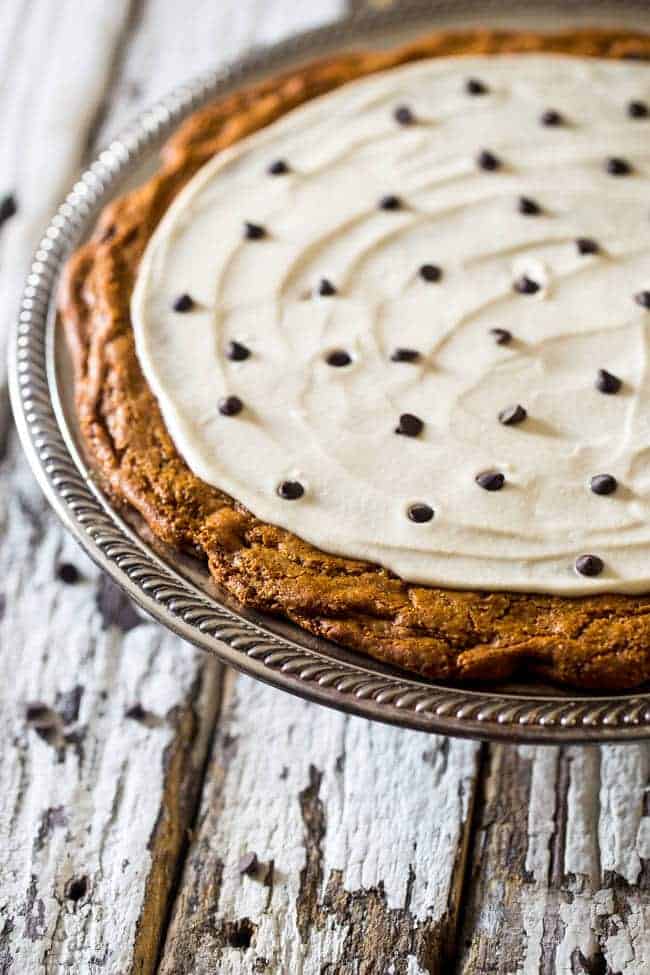 Paleo Cookie Pizza with Cashew Cream - Who needs paleo cookies when you could have a Paleo Cookie Pizza?! This chocolate chip cookie pizza is topped with cashew cream and is a gluten free dessert that is secretly healthy! | Foodfaithfitness.com | @FoodFaithFit