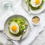 Paleo Zucchini Noodles with Everything Pesto and Fried Eggs - Zucchini noodles are mixed with creamy pesto and then topped with fried eggs. It's an easy, light and healthy, meatless weeknight dinner! | Foodfaithfitness.com | @FoodFaithFit