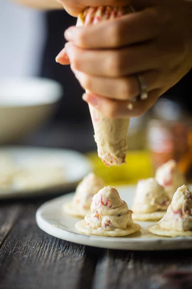 Sun-Dried Tomato Hummus and Goat Cheese Pesto Bites - These quick and easy bites use creamy goat cheese and tangy hummus! They're a healthy, spring appetizer that are only 40 calories and 1 SmartPoint! | Foodfaithfitness.com | @FoodFaithFit