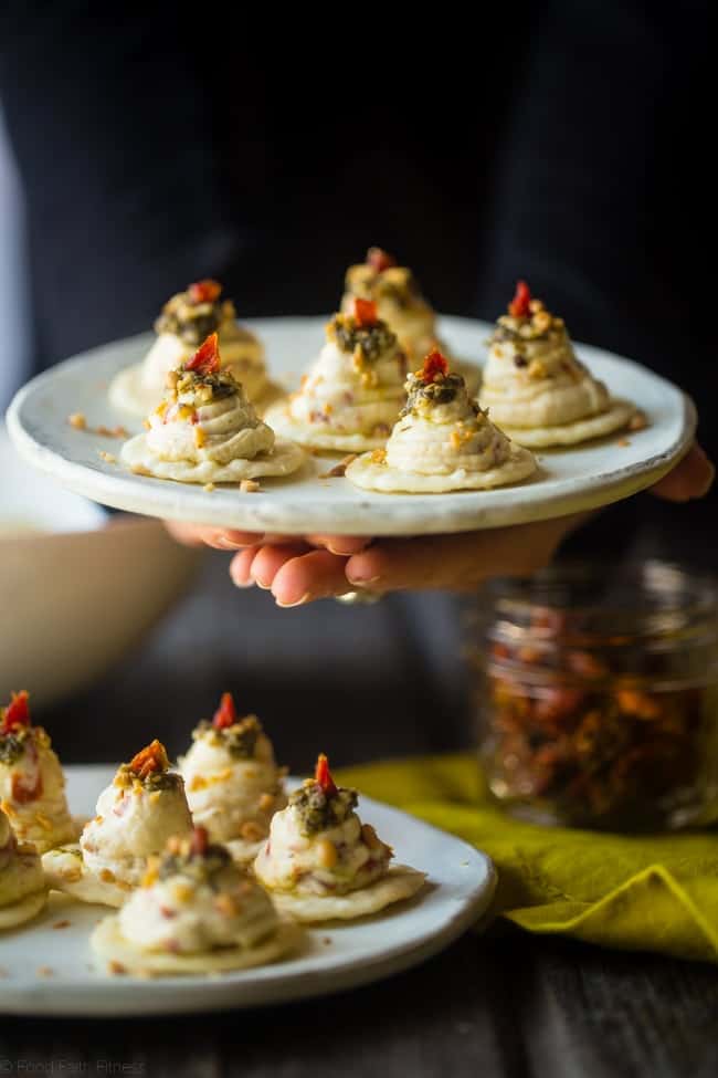 Sun-Dried Tomato Hummus and Goat Cheese Pesto Bites - These quick and easy bites use creamy goat cheese and tangy hummus! They're a healthy, spring appetizer that are only 40 calories and 1 SmartPoint! | Foodfaithfitness.com | @FoodFaithFit