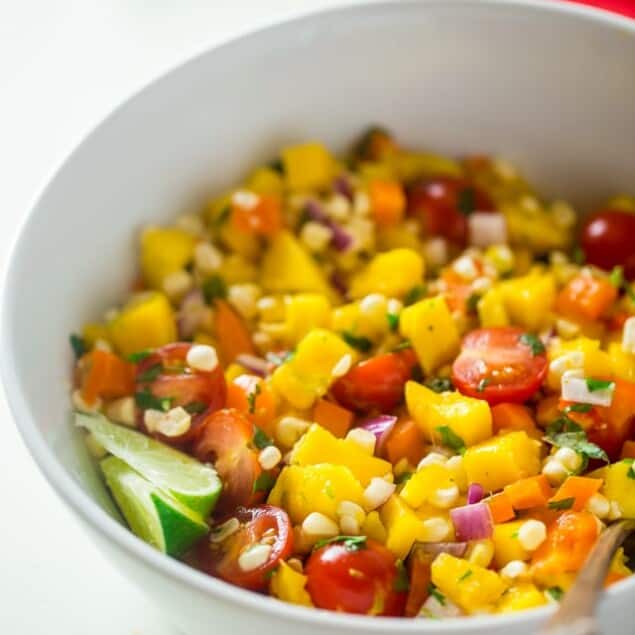 Vegan Fresh Corn and Mango Salad - This healthy salad has fresh corn, juicy, sweet mangos and tons of crispy, fresh vegetables! It's the perfect, quick and easy side dish for summer that is under 100 calories! | Foodfaithfitness.com | @FoodFaithFit