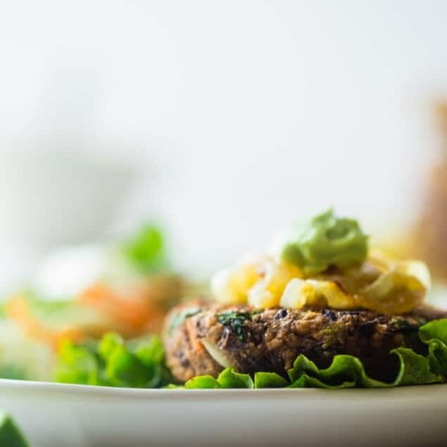 Black Bean Power Burger with Avocado Crema - This black bean burger is so tender and juicy you would never know it's meatless! Load it up with caramelized onions and avocado crema for a healthy, gluten free meal that's easy to prepare! | Foodfaithfitness.com | @FoodFaithFit