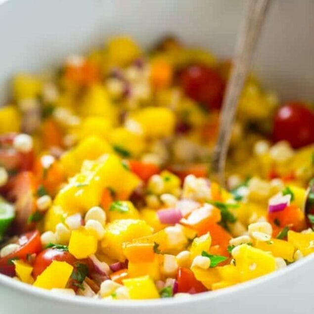 Vegan Fresh Corn and Mango Salad - This healthy salad has fresh corn, juicy, sweet mangos and tons of crispy, fresh vegetables! It's the perfect, quick and easy side dish for summer that is under 100 calories! | Foodfaithfitness.com | @FoodFaithFit