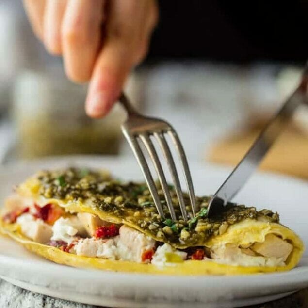 Pesto Chicken Egg White Omelette with Goat Cheese - This quick and easy, protein packed egg white omelette is mixed with chicken, creamy goat cheese and topped with pesto! It's a low carb and gluten free breakfast for busy mornings! | Foodfaithfitness.com | @FoodFaithFit