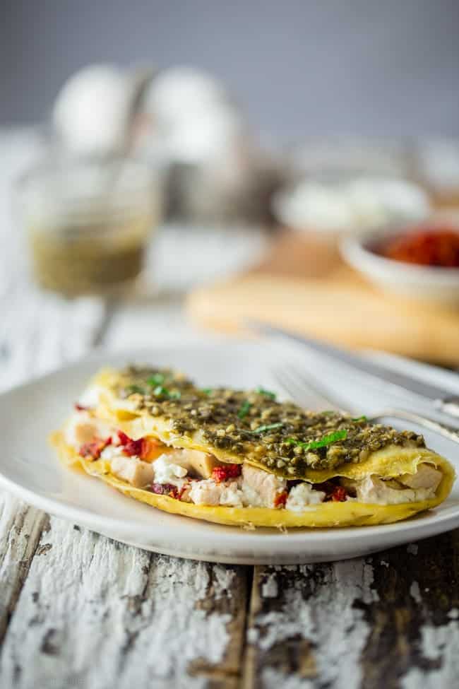 Pesto Chicken Egg White Omelette with Goat Cheese - This quick and easy, protein packed egg white omelette is mixed with chicken, creamy goat cheese and topped with pesto! It's a low carb and gluten free breakfast for busy mornings! | Foodfaithfitness.com | @FoodFaithFit