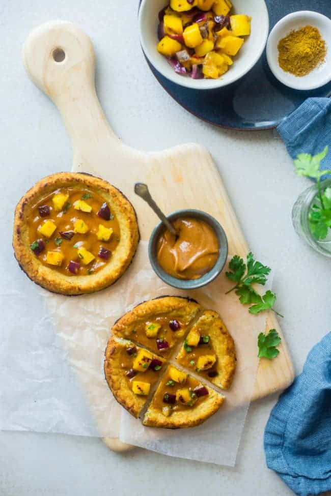 Mango Curry Cashew Paleo Pizza - This pizza is made with a cauliflower crust, topped with creamy, spicy cashew sauce and sweet mango! It's a healthy gluten, grain and dairy free alternative for pizza night! | Foodfaithfitness.com | @FoodFaithFit