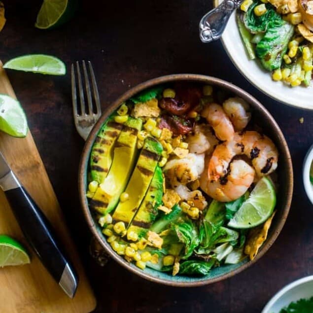 Honey Lime Grilled Avocado Shrimp Nacho Bowls - These smoky-sweet bowls have glazed honey lime grilled avocado, spicy shrimp. tomato and corn! Top them with gluten free nacho chips for a healthy, summer meal that's packed with flavor! | Foodfaithfitness.com | @FoodFaithFit