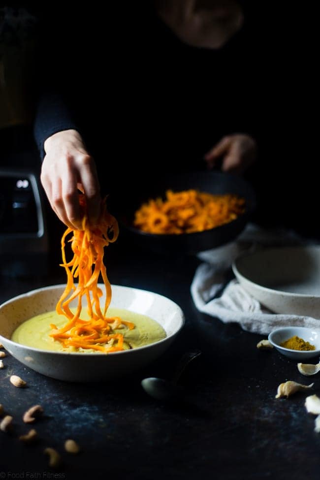  Vegan Cauliflower Coconut Curry Soup with Sweet Potato Noodles - This easy soup is made extra creamy with cauliflower and cashew cream! Top it with sweet potato noodles for a gluten free meal that is paleo friendly! | Foodfaithfitness.com | @FoodFaithFit