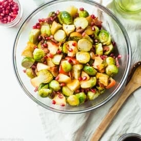 Superfood Roasted Brussels Sprouts with Bacon - These salty-sweet roasted Brussels sprouts are tender, crispy and have a surprise superfood pomegranate crunch! They're the perfect, paleo-friendly healthy Thanksgiving side! | Foodfaithfitness.com | @FoodFaithFit