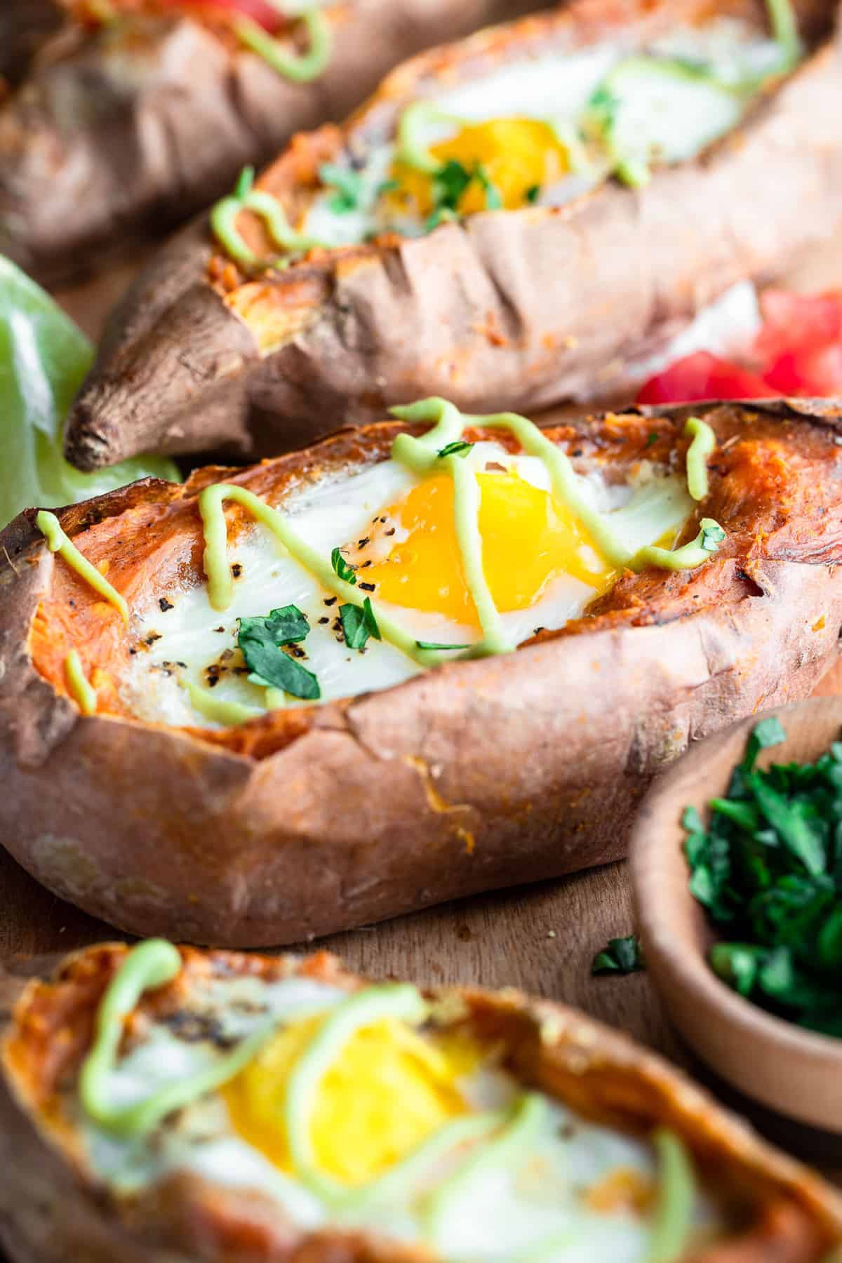 twice baked mexican sweet potatoes with eggs and avocado sauce drizzled on top