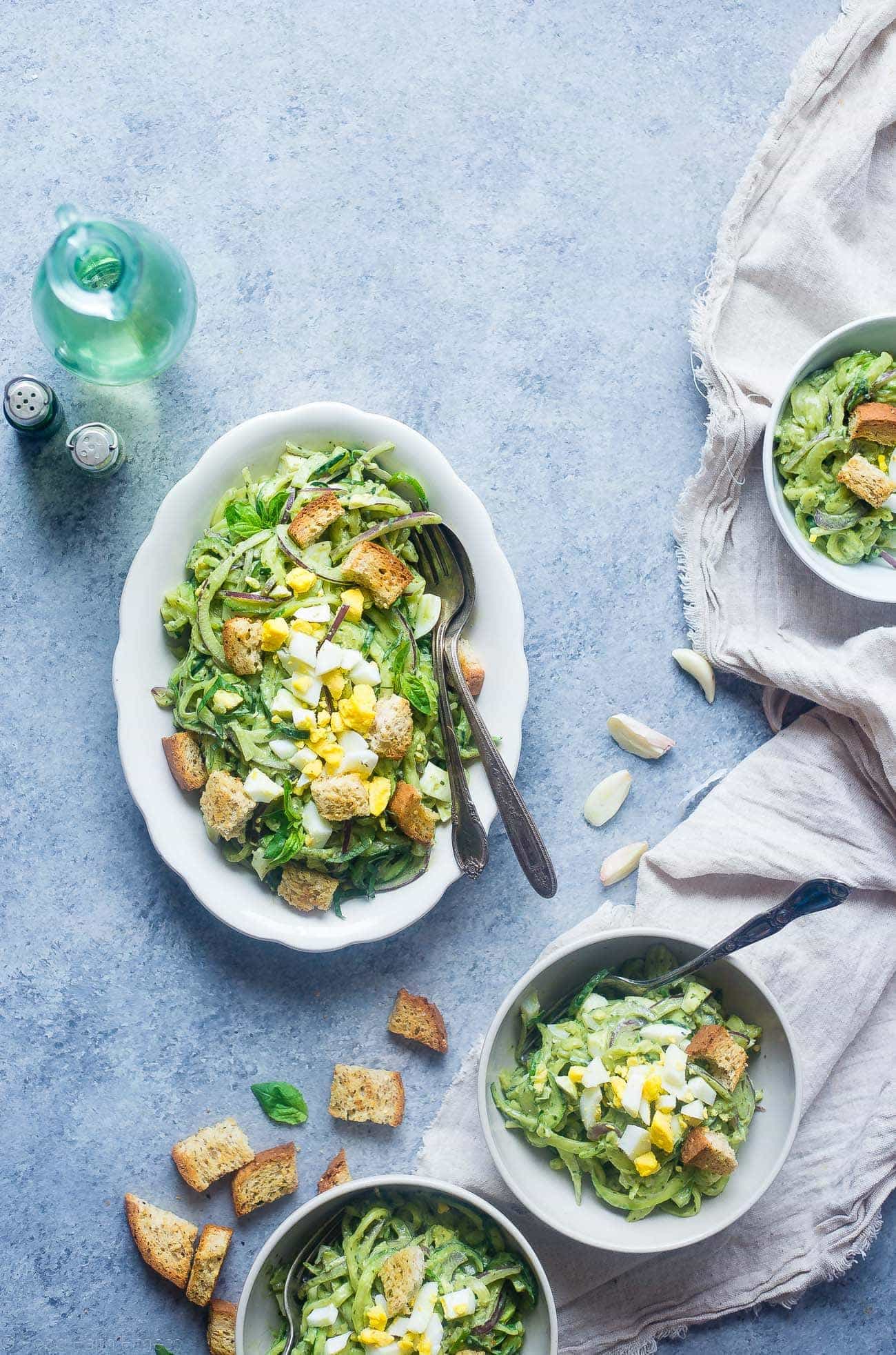Avocado Pesto Zucchini Noodle Pasta Salad - This gluten free, healthy pasta salad uses zucchini noodles and has crunchy croutons and creamy avocado pesto! It's a low carb, easy spring side dish that's perfect for Easter! | Foodfaithfitness.com | @FoodFaithFit