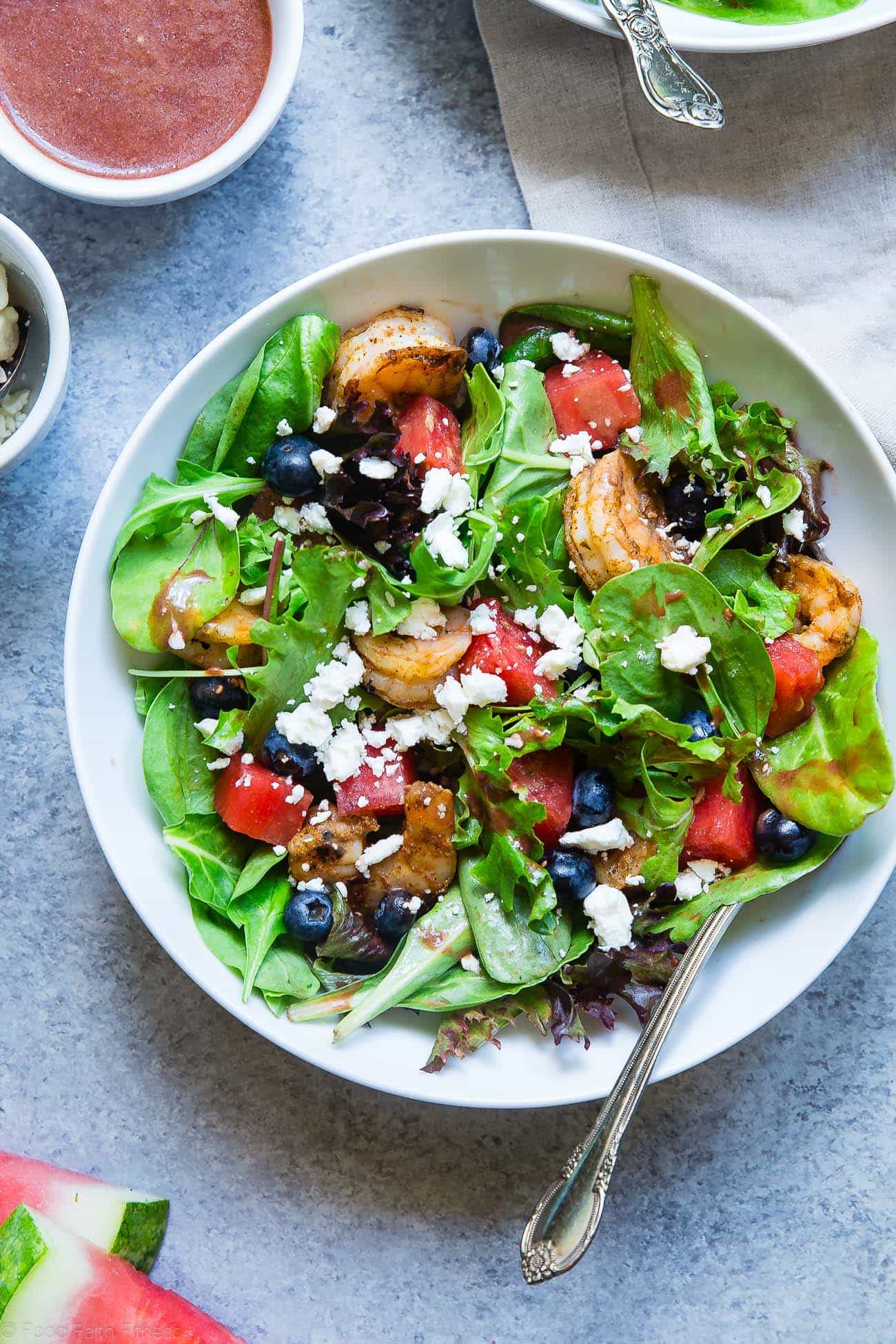 Closeup photo of watermelon feta salad with Cajun shrimp in a bowl. Recipe on Foodfaithfitness.com