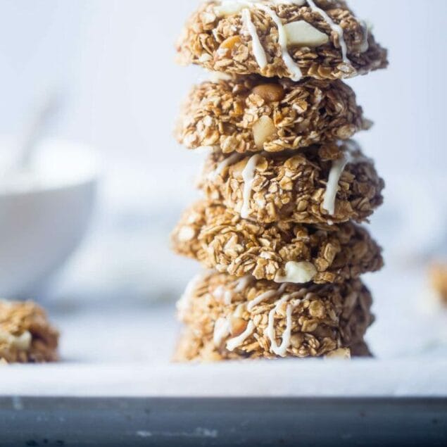 A stack of no bake white chocolate macadamia nut cookies on a table. Recipe on Foodfaithfitness.com