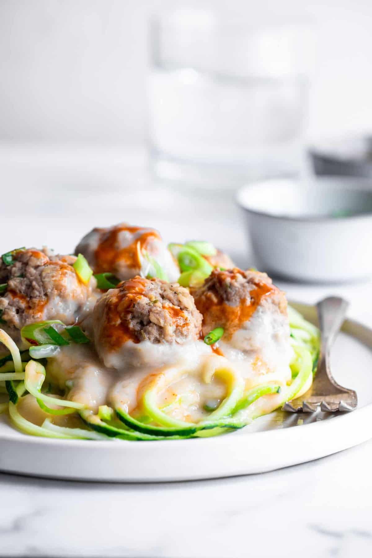Low carb buffalo chicken meatballs on a pile of zucchini noodles