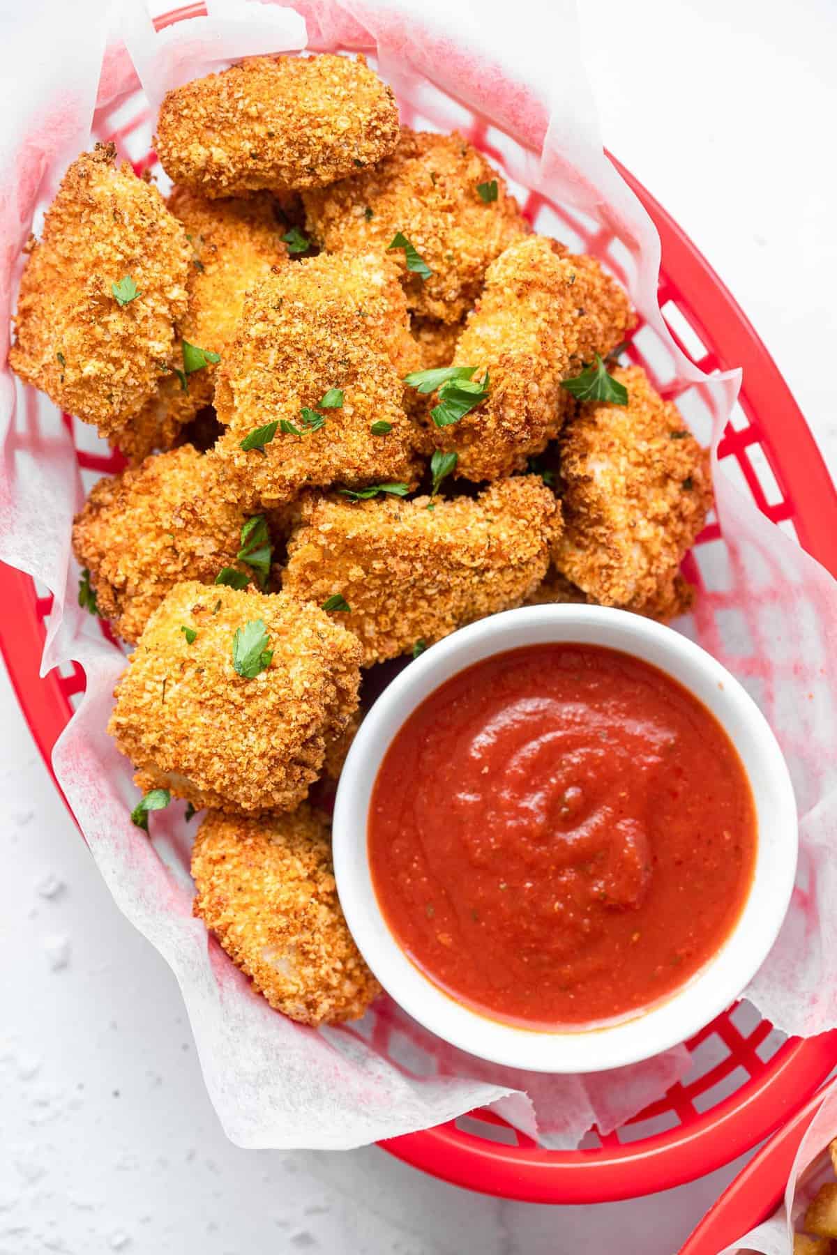 Air fryer chicken nuggets in a serving basket with ketchup