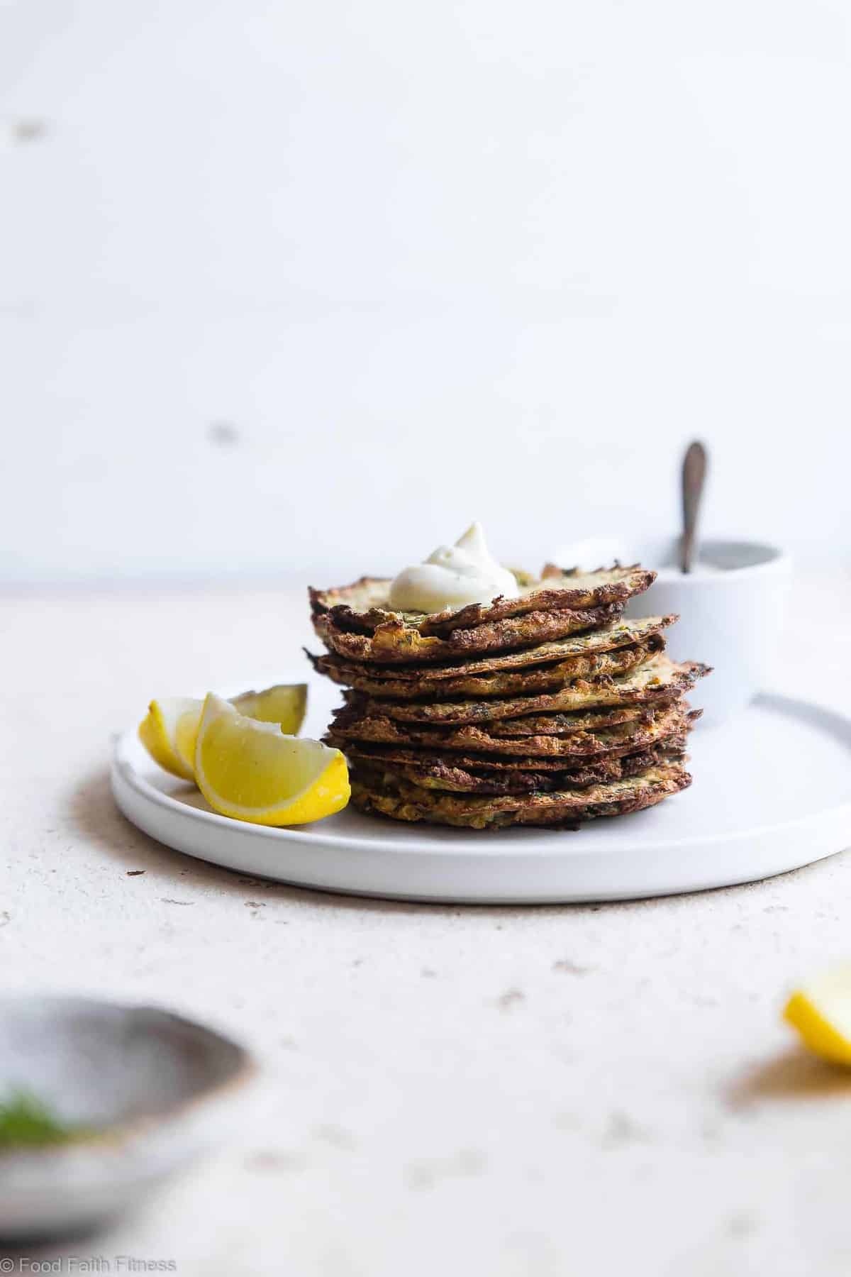 Paleo Baked Zucchini Fritters - These EAS, keto Baked Zucchini Fritters are served with an addicting lemon dill drop and are SO crispy, you'll never believe they're baked not fried! Gluten free, low carb, whole30 and insanely tasty! | #Foodfaithfitness | #Glutenfree #keto #Paleo #Whole30 #Lowcarb
