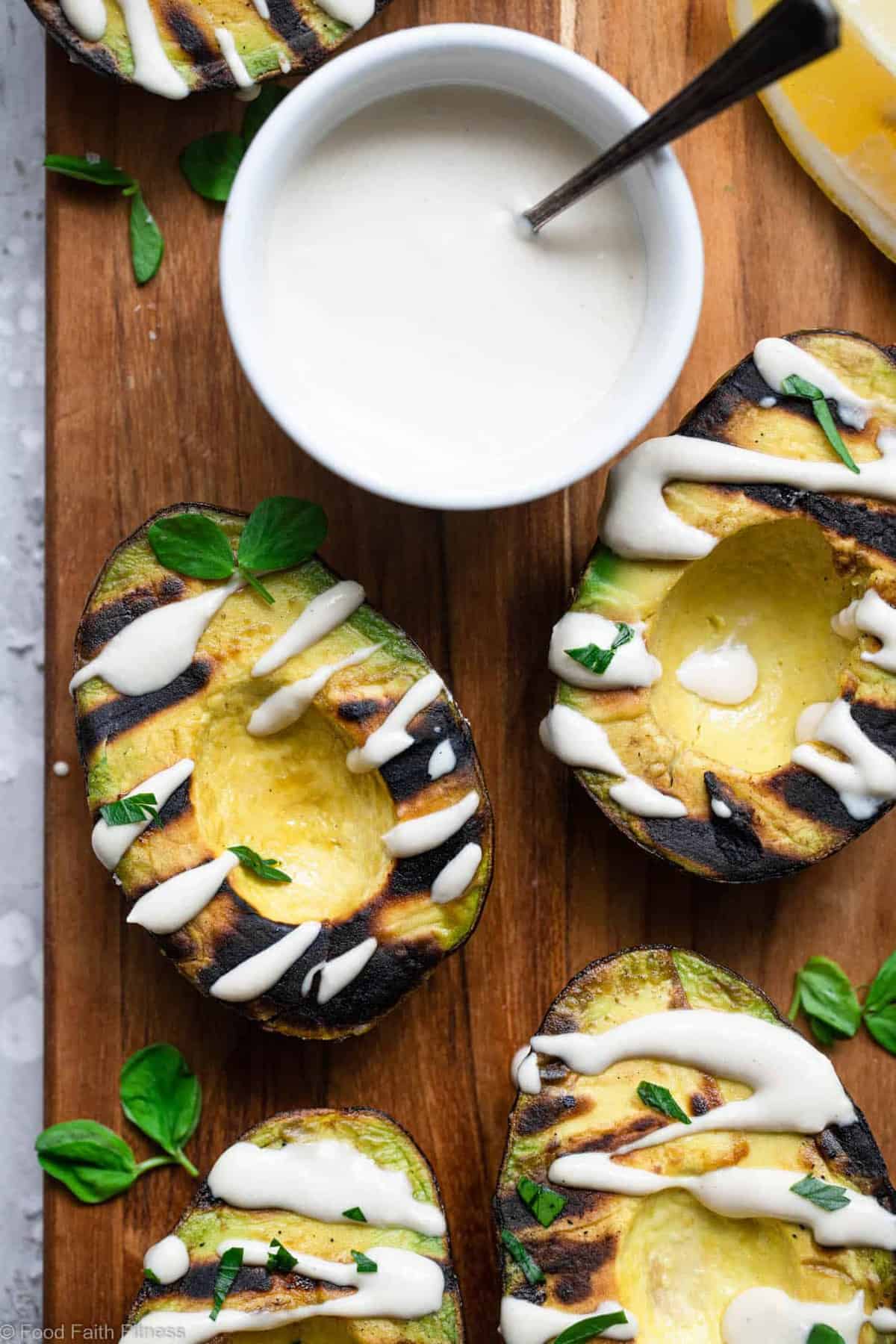 Grilled Avocado with Feta Tahini Sauce - These smoky and creamy grilled avocados are drizzled with a sweet and tangy feta and tahini sauce for an easy summer dinner that's healthy , keto, low carb and delicious! | #Foodfaithfitness | #Glutenfree #healthy #lowcarb #keto #grilling