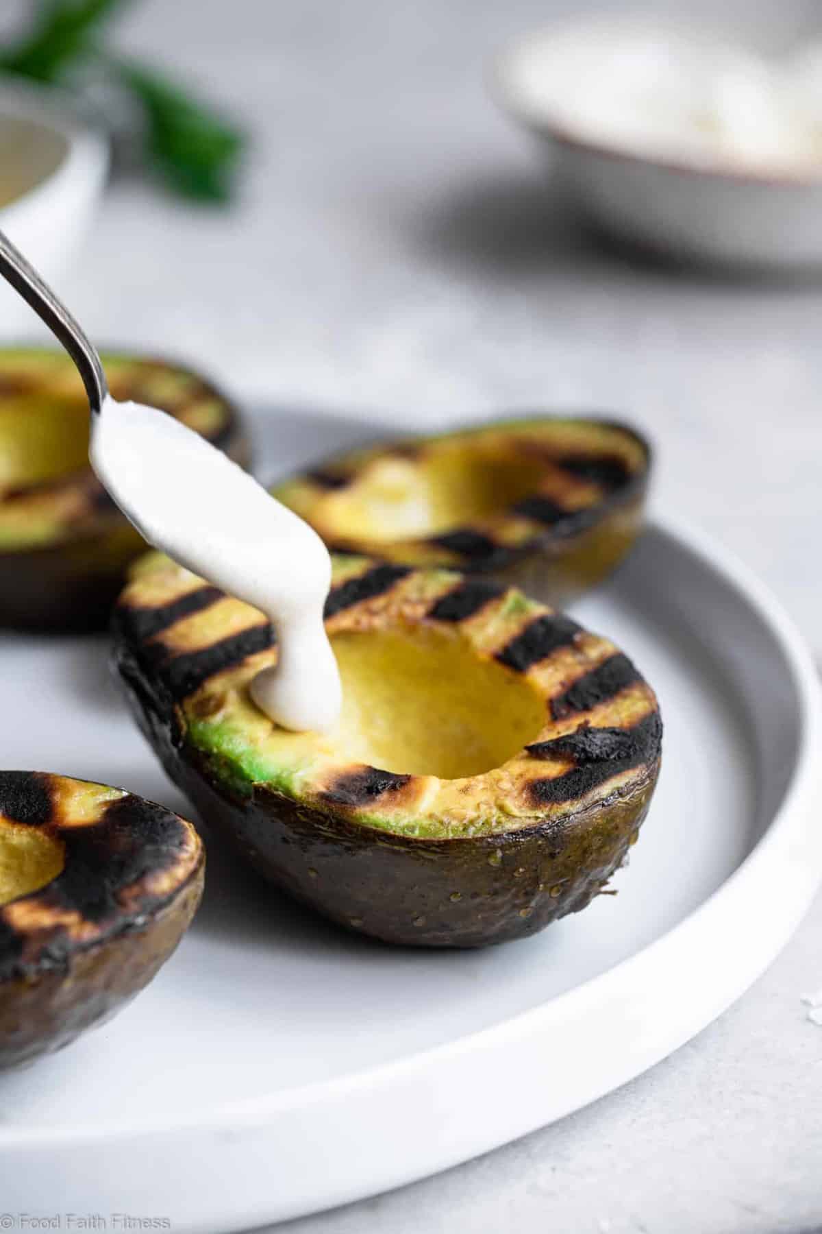 Grilled Avocado with Feta Tahini Sauce - These smoky and creamy grilled avocados are drizzled with a sweet and tangy feta and tahini sauce for an easy summer dinner that's healthy , keto, low carb and delicious! | #Foodfaithfitness | 