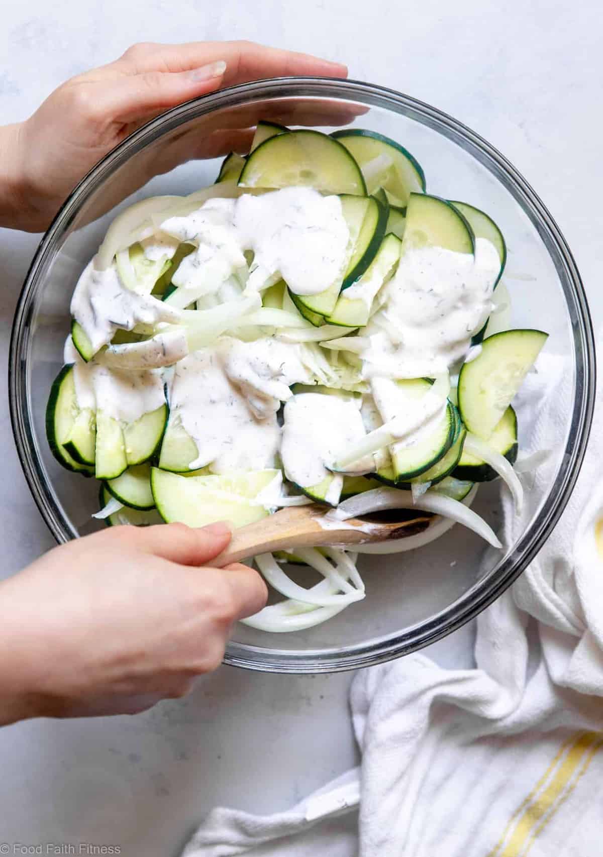 Person mixing a low carb cucumber salad recipe