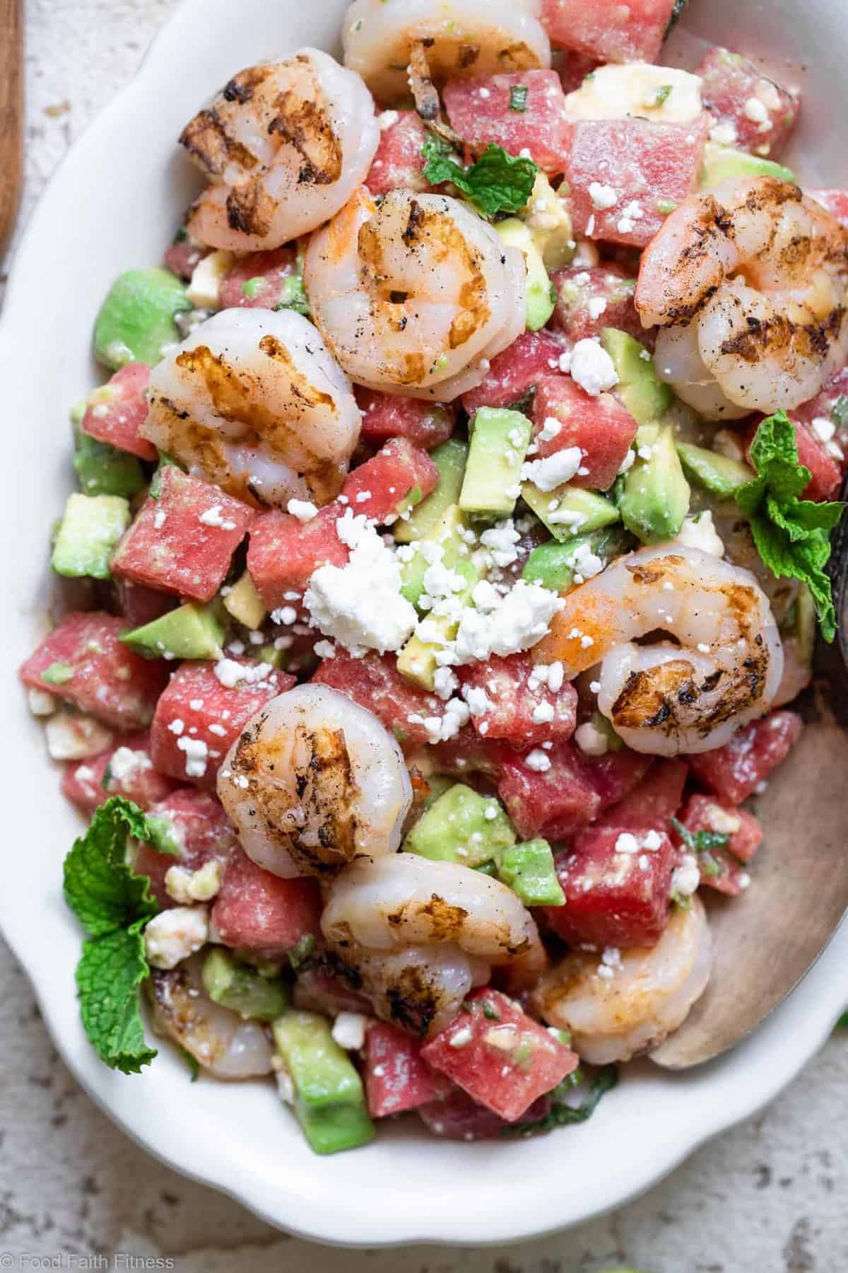 Close up photo of a bowl filled with shrimp avocado salad with watermelon