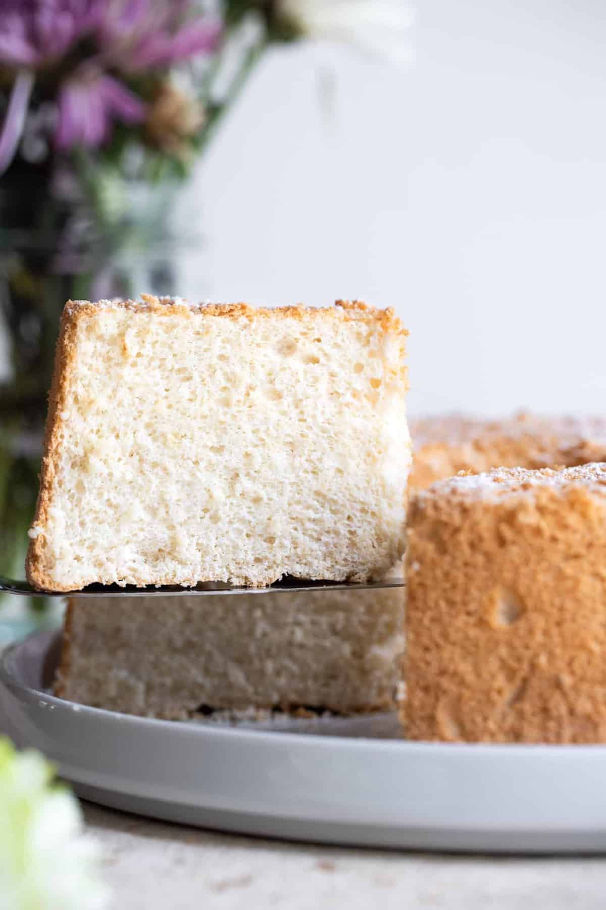 Sugar free angel food cake slice lifting out of a cake