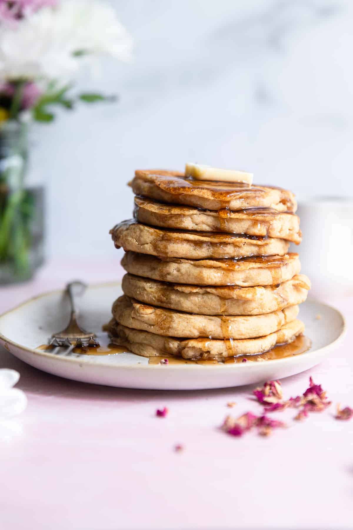 a stack of Healthy Vegan Pancakes with butter and syrup