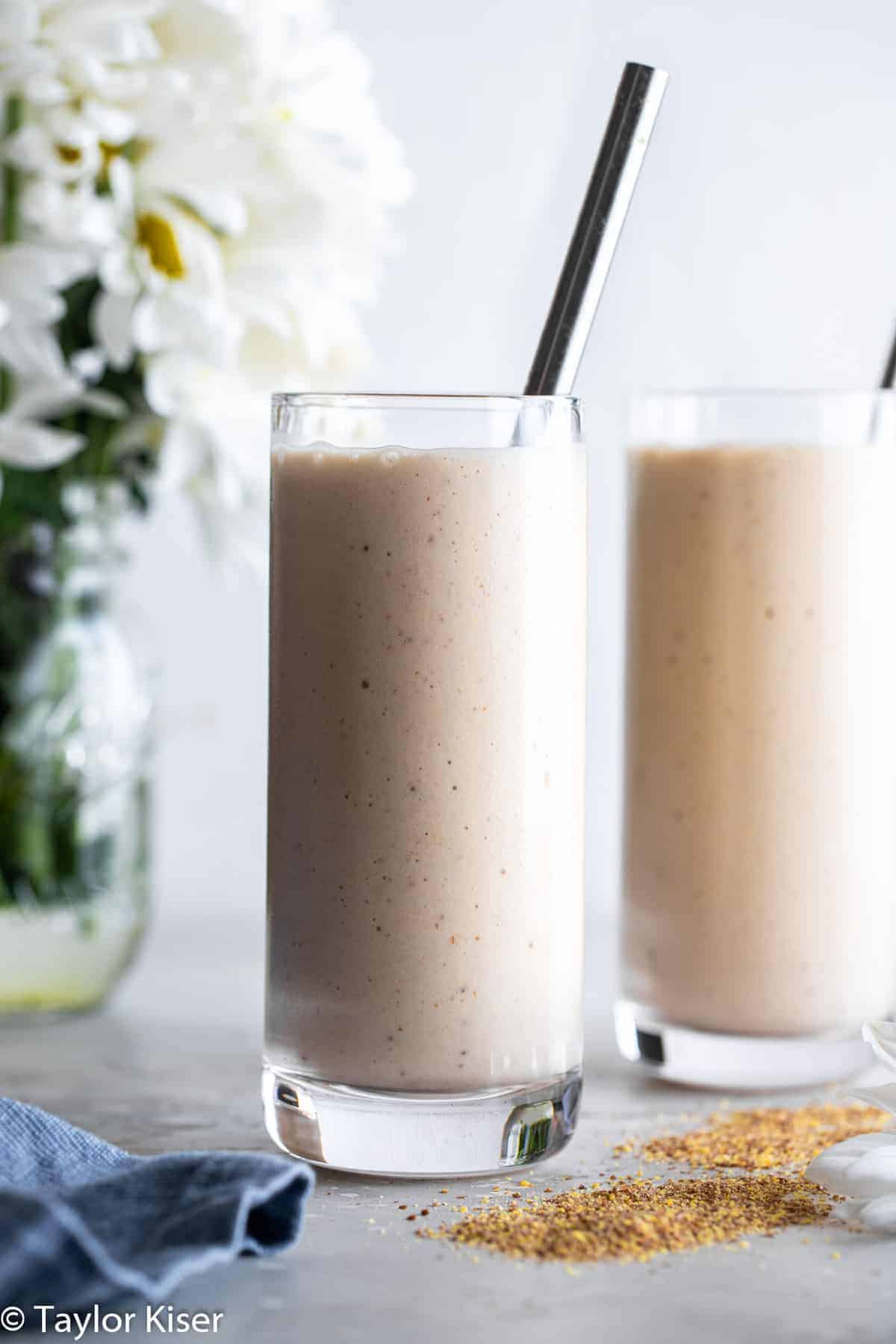 twoBanana Flaxseed Smoothie on a table with flowers
