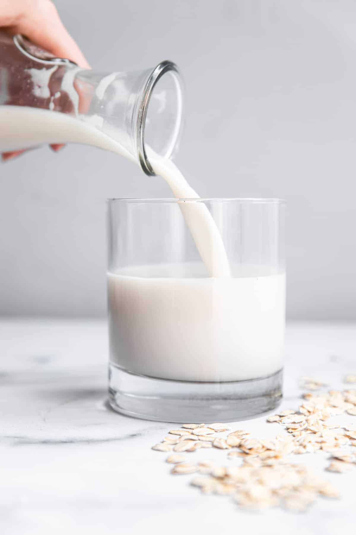 Homemade oat milk being poured into a cup