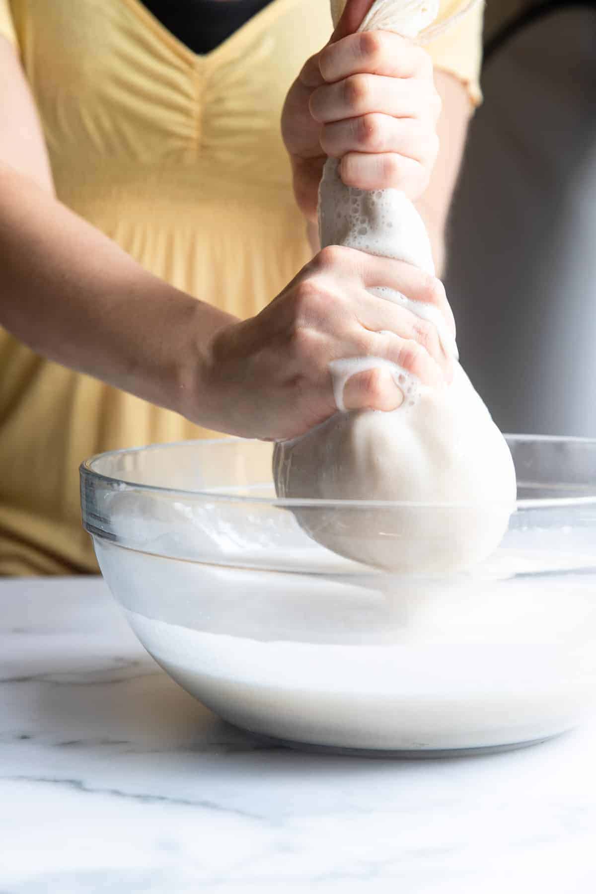Ringing out an oatmilk recipe in a nut milk bag