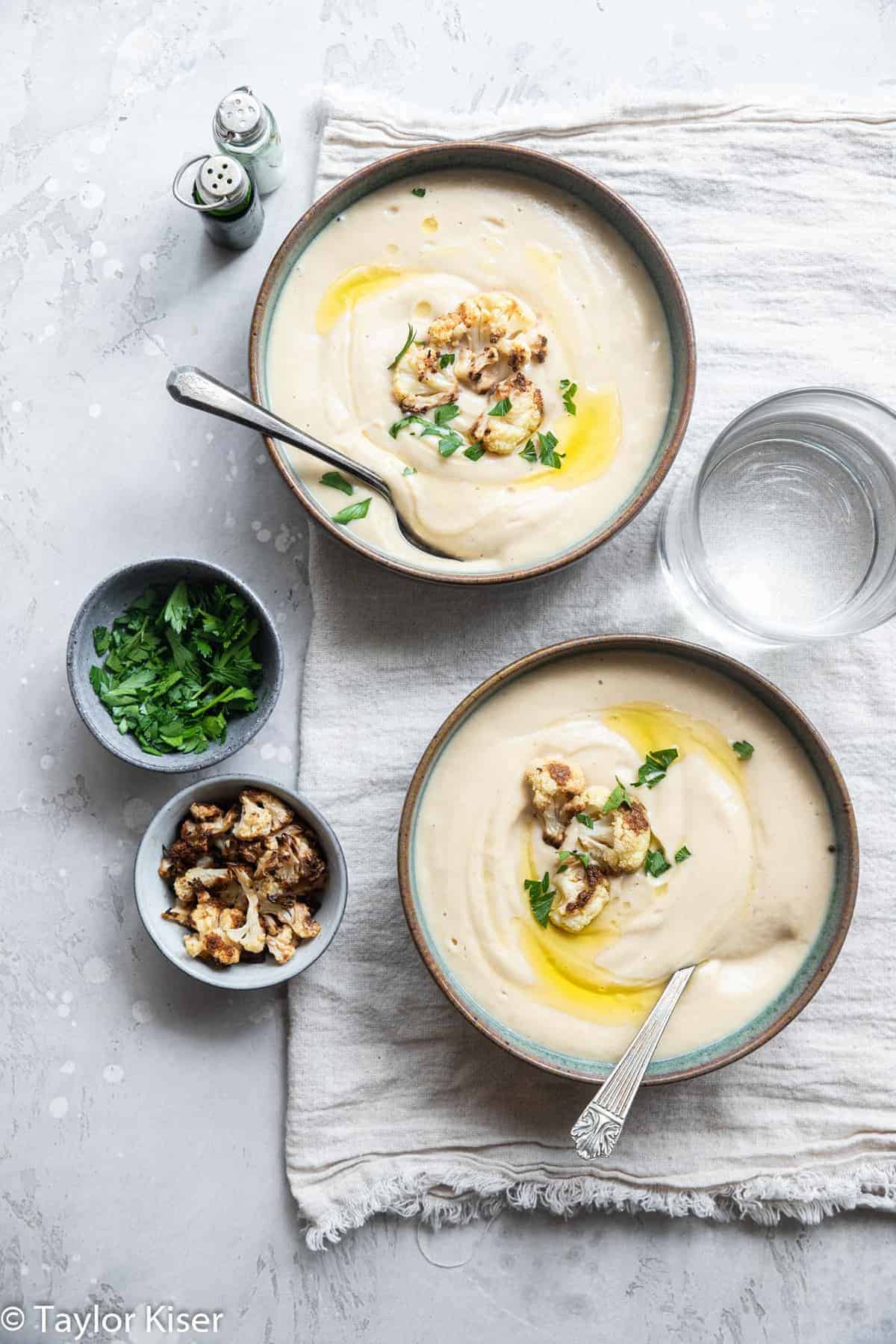 Roasted cauliflower soup in two bowls on a tabel