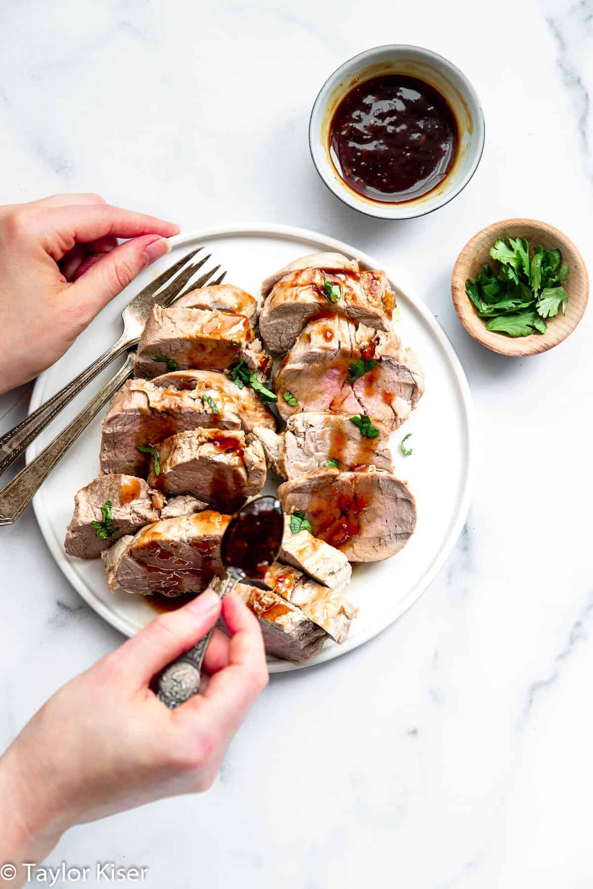 Instant Pot Pork Tenderloin on a plate with a hand holding a fork