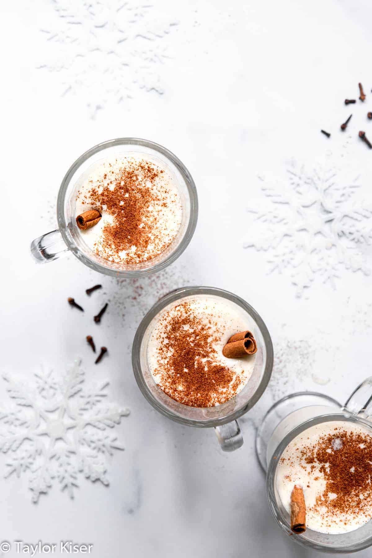 3 glasses of low carb eggnog with cinnamon sticks and nutmeg on top