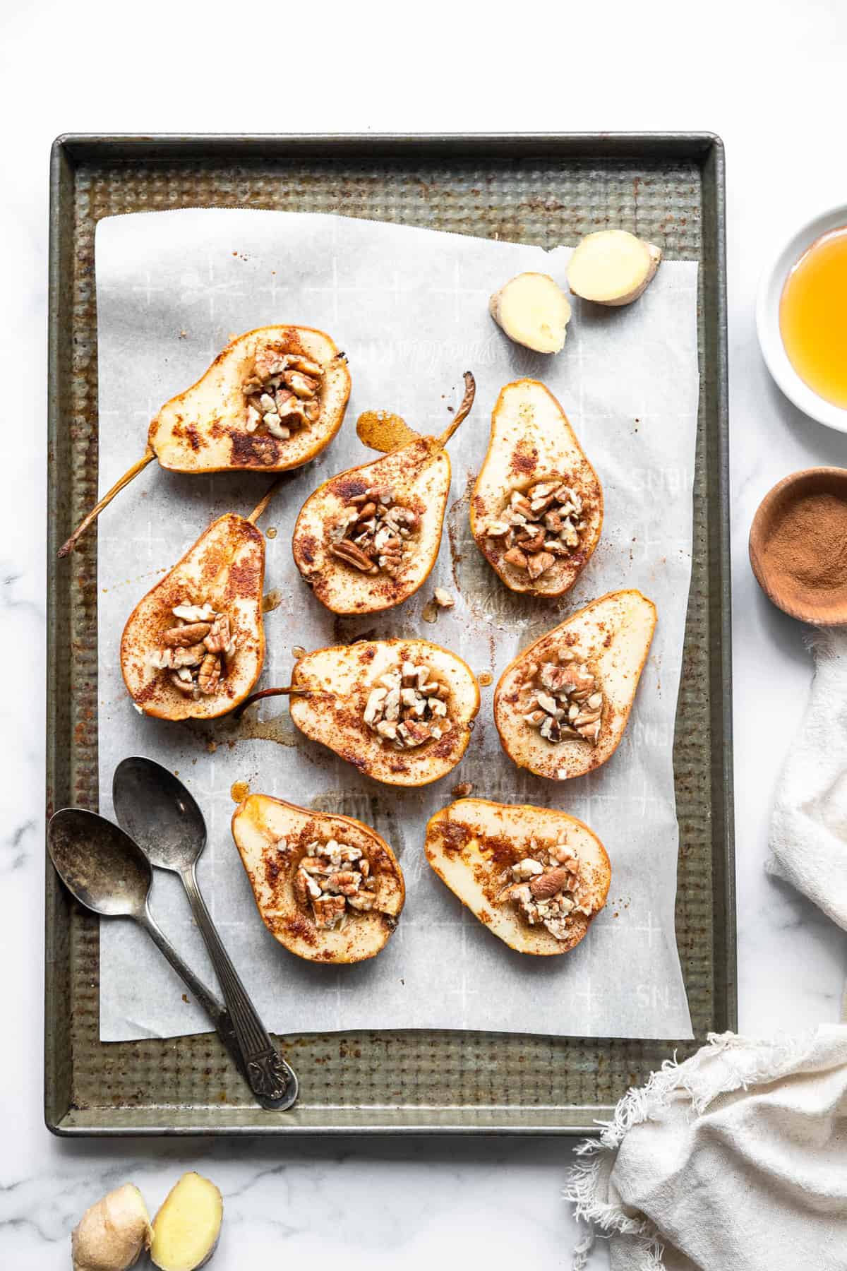 healthy baked pears filled with pecans on a cookie sheet