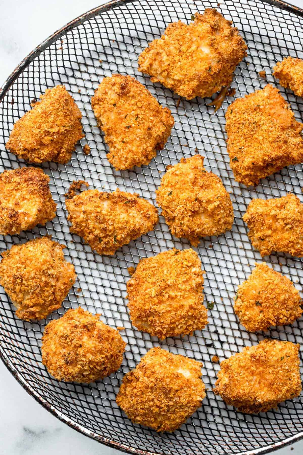 chicken nuggets in air fryer on a mesh basket